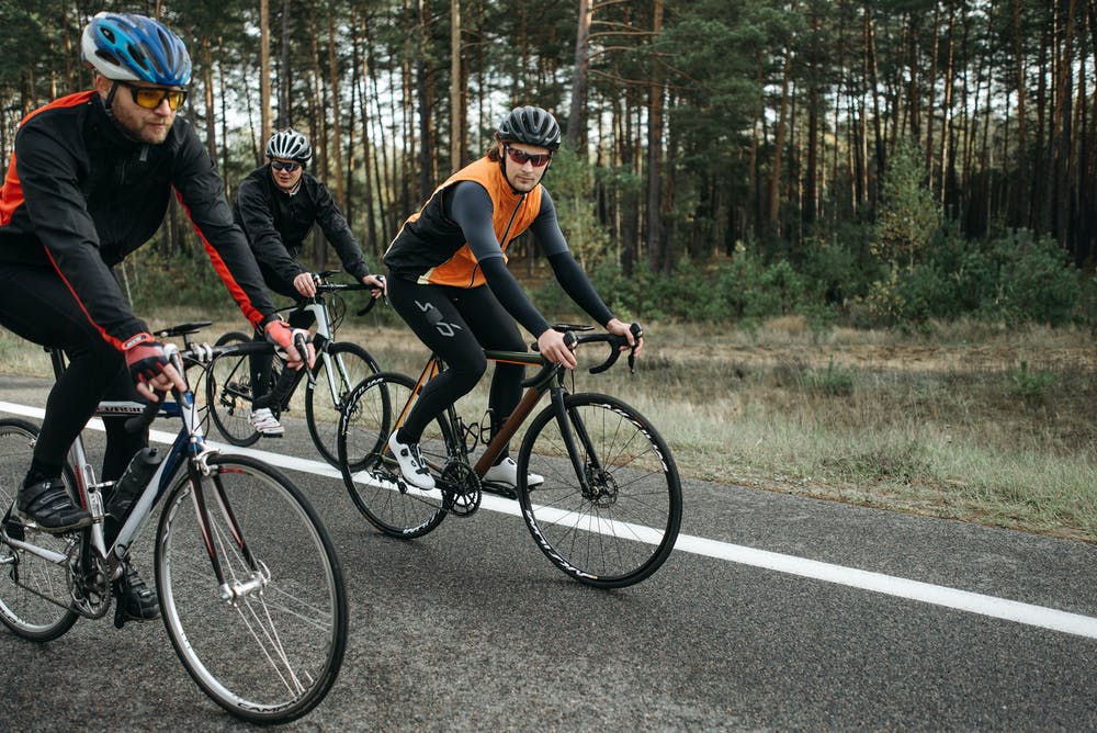 An image of 3 cyclists road cycling